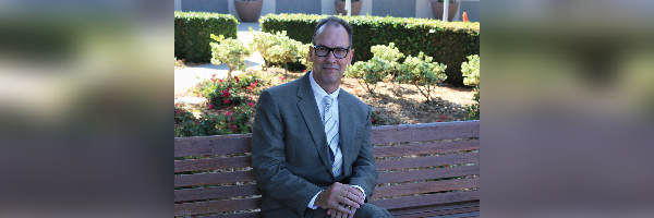Dr. Dunn seated on a bench outdoors