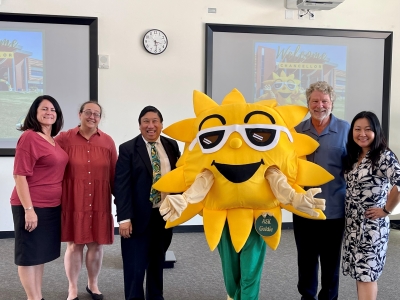 Chancellor Yamamura with college staff and a gold star mascot