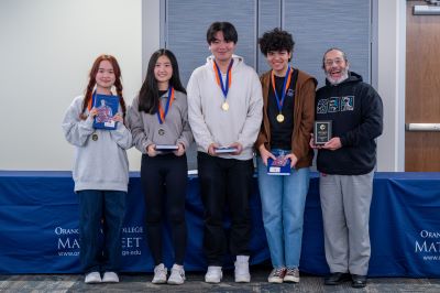 Beckman High School students and their advisor pose with their medals and prizes after winning the 2024 OCC Math Meet