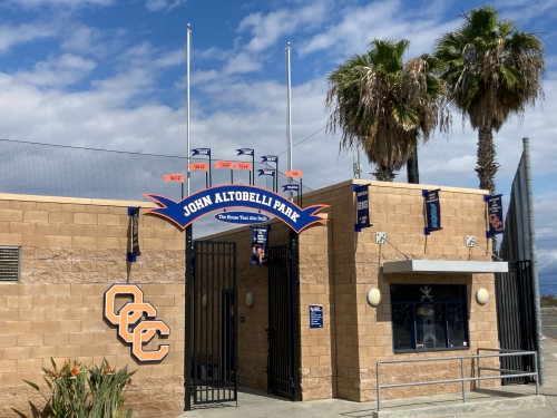 An entrance with sign stating John Altobelli Park.